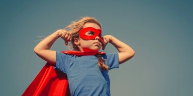 Child in superhero costume flexing